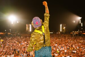 Jovanotti di spalle dal palco con pugno alzato davanti al pubblico al Jova Summer Party.