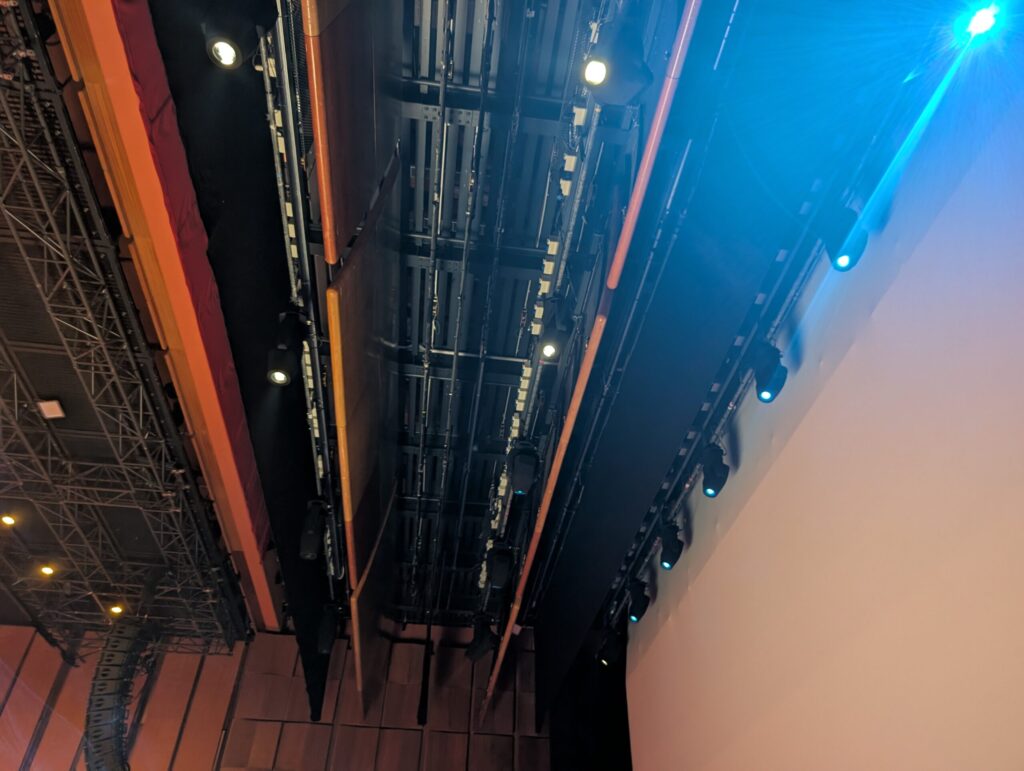 Vista dal basso verso la grigliata tecnica a soffitto con proiettori Chauvet Professional